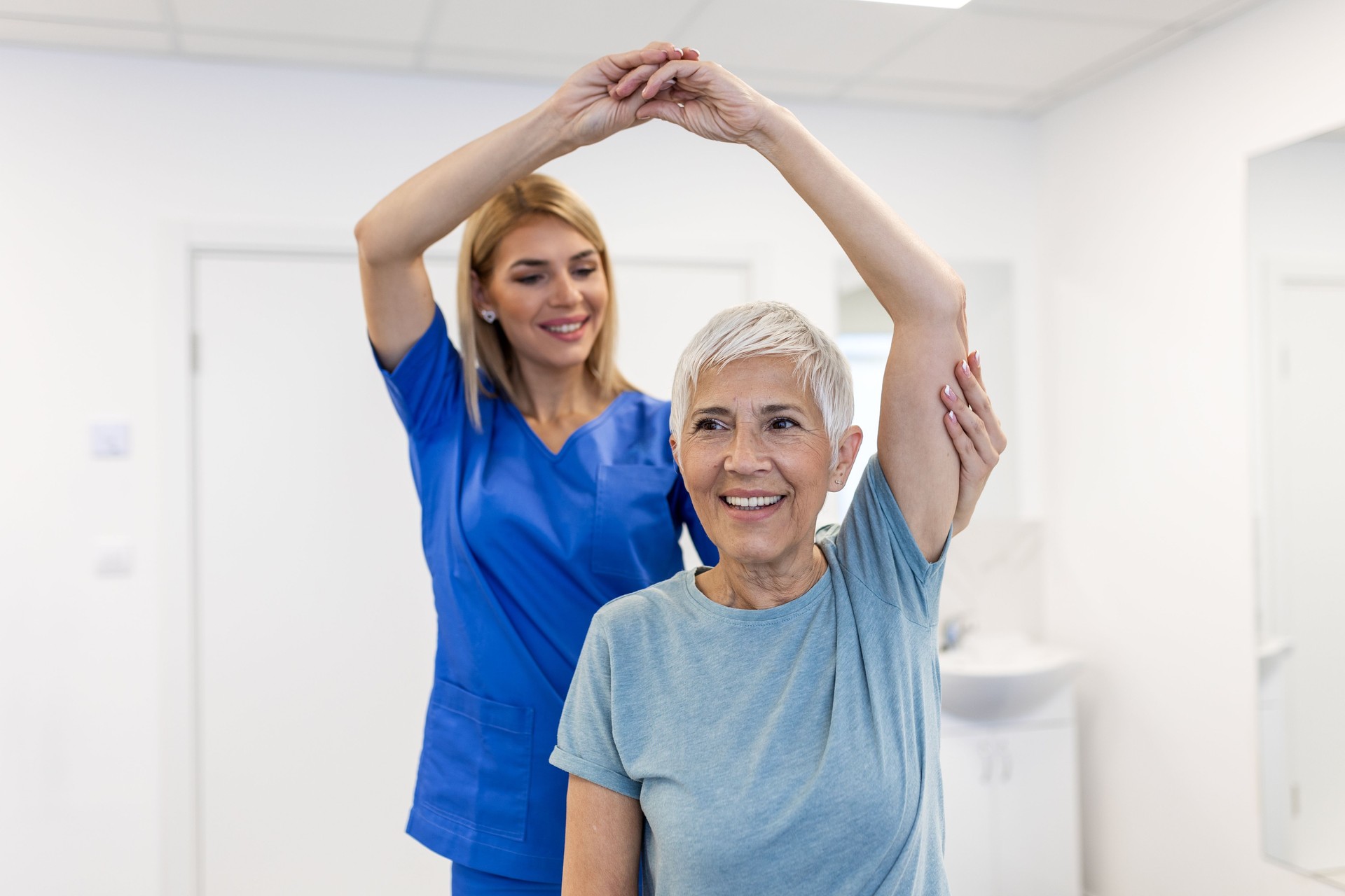 Female Physiotherapist working examining treating injured arm of senior female patient, stretching and exercise, Doing the Rehabilitation therapy pain in clinic.